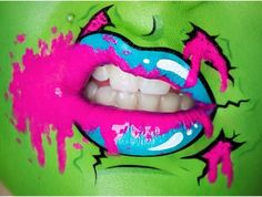 a woman's mouth with pink and blue paint on her lips, painted green