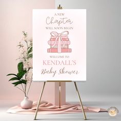 a welcome sign for a baby shower is displayed on an easel next to flowers