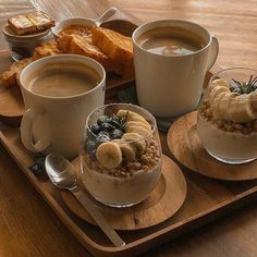 two cups of coffee and some desserts on a tray