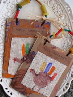 three thanksgiving cards on a white plate with string and twine hanging from the handles