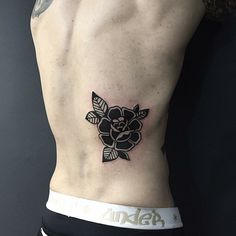 a man with a flower tattoo on his stomach