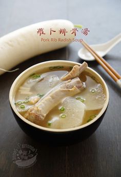 a bowl filled with soup next to two chopsticks