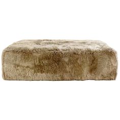 a fur ottoman that is sitting on top of a white surface with no one around it