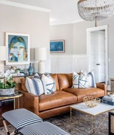 a living room filled with furniture and a chandelier hanging above the couches