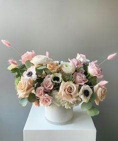 a white vase filled with lots of flowers