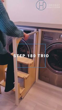 a person sitting on a stool next to a washer and dryer