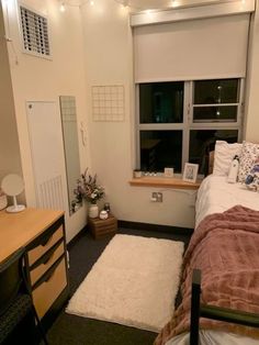 a bed room with a neatly made bed next to a window and a rug on the floor