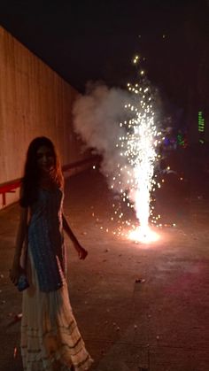 a woman standing in front of a firework display