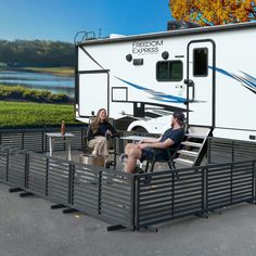 a man and woman sitting in front of an rv