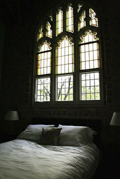 a bed sitting under a window in a dark room