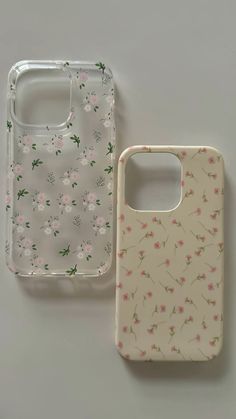 two cell phones sitting next to each other on a white surface with pink and green flowers