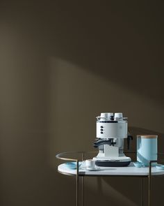 a table with a coffee cup on it and a small machine sitting next to it