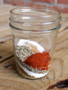 a jar filled with spices sitting on top of a wooden table