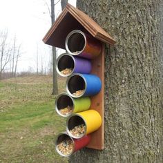 a bird house that is hanging on the side of a tree with birds in it