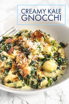 a white bowl filled with pasta and spinach