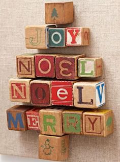 a christmas tree made out of wooden blocks with the words noelly merry written on them