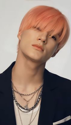 a man with pink hair wearing a black jacket and silver chain necklace on his neck