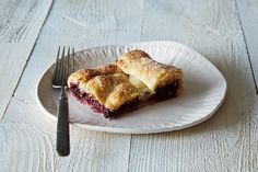 a piece of pie sitting on top of a white plate next to a knife and fork