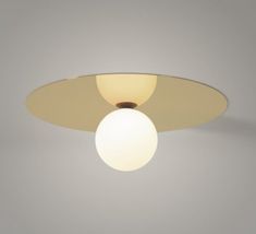 a ceiling light with a white ball hanging from it's center point on a gray wall