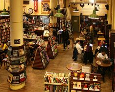 the inside of a bookstore filled with lots of books and people sitting at their desks