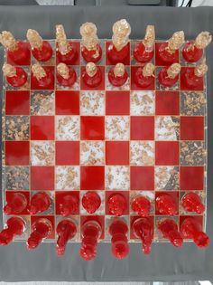 a red and white checkerboard board with gold pieces on the top, as well as other items