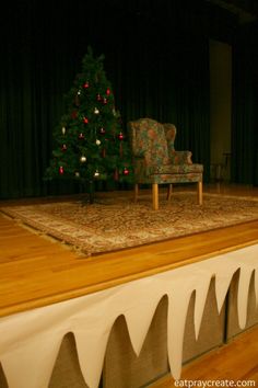 a christmas tree sitting on top of a wooden floor in front of a couch and chair