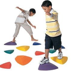 two young boys playing with different colored circles on the floor in front of each other