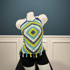 a mannequin wearing a blue and yellow crochet top