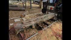 an old wooden bench sitting in the middle of a forest filled with logs and branches