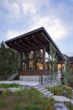 a modern house with an open porch and stairs leading up to the upper floor area