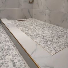 a bathroom with marble counter tops and gold trim around the edges, along with a shower head