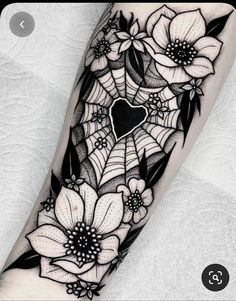 a black and white tattoo with flowers on the arm