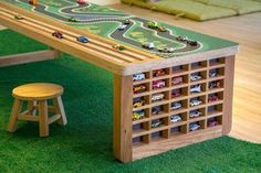 a wooden table with toy cars on it and two stools in front of it