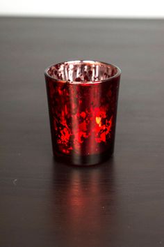 a red cup sitting on top of a wooden table