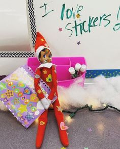 an elf is sitting on the floor with presents