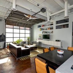 a living room filled with furniture and a flat screen tv mounted to the wall in front of a window