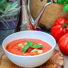 a bowl of tomato soup on a cutting board