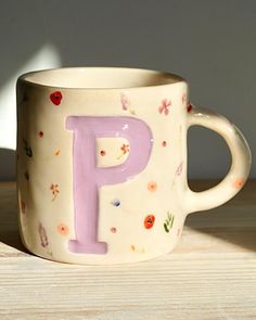 a coffee cup with the letter p painted on it