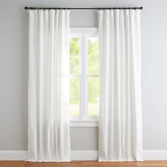 a white curtain hanging in front of a window