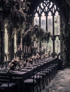 a long table is set up in front of a large window with candles and flowers on it