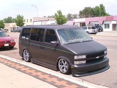 the van is parked on the side of the road next to the curb with other cars