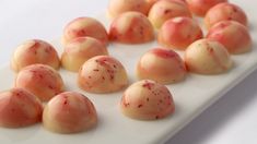 a white plate topped with lots of red and yellow candies on top of a table