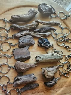 several pieces of driftwood are arranged on a wooden board with metal chains and hooks