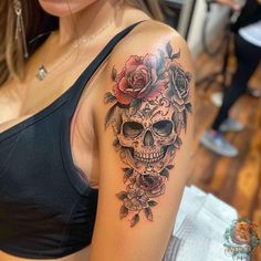 a woman with a skull and roses tattoo on her arm