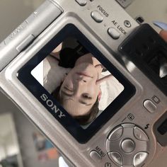 a person holding up a camera with a picture on it