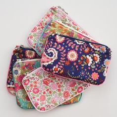 four floral pouches are stacked on top of each other