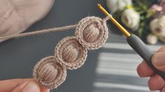 someone is crocheting three circles on a piece of yarn with a knitting needle