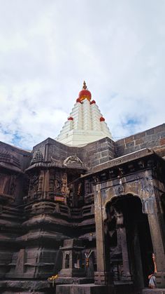 the top of an ornate building with red and white decorations