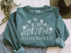 Homemaker Sweatshirt, Homestead Sweatshirt, Homesteading Sweatshirt, Homestead Shirt, Homesteading Shirt, Homesteader Shirt, Homesteader, Homestead This style sweatshirt is UNISEX, runs true to size, and has a great fit.  Order up one or two sizes for an oversized fit!  If you are unsure of your size, please refer to the size chart provided in the additional photos. Our sweatshirts are made of cotton and polyester making it soft, yet, durable.  Fiber content may vary with colors.  Because all of our sweatshirts are made to order, we do not accept returns or exchanges once the order has been placed.  However, if your item has arrived damaged or has a manufacturing error we will offer a free replacement or full refund if you contact us within 30 days from the day your item arrived. Productio Homestead Shirt, Style Sweatshirt, Lilly Pulitzer Shorts, Order Up, Hand Designs, Print Patterns, Shirt Designs, Graphic Tees, Size Chart