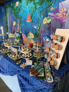 an under the sea themed birthday party with cupcakes and desserts on a table